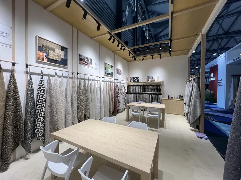Swatch walls and meeting tables inside the Huaming booth, Shanghai 2026