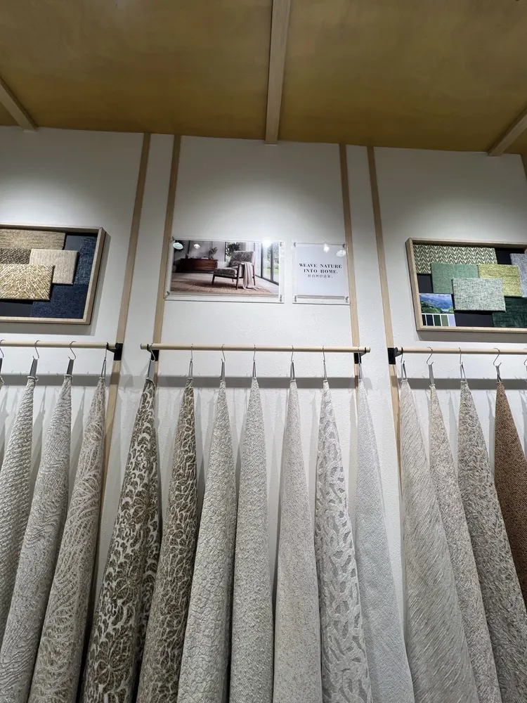 Natural-tone upholstery swatches under the WEAVE NATURE INTO HOME sign, Huaming booth