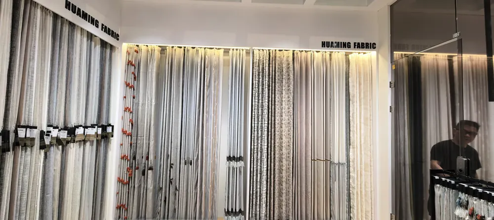 HUAMING FABRIC booth signage above a fabric swatch wall, Shanghai home textile fair 2026