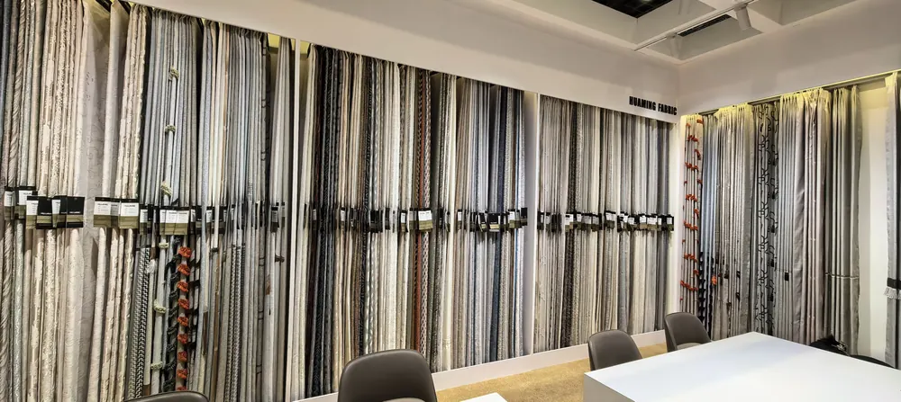 Huaming Fabric booth meeting area with fabric swatch walls, Shanghai home textile fair 2026