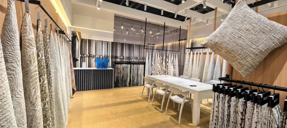 Huaming Fabric booth overview with swatch walls and meeting table, Shanghai home textile fair 2026