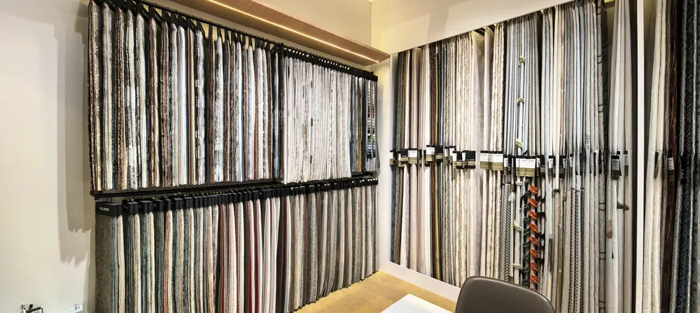 Huaming Fabric natural-tone upholstery and curtain swatch wall at the 2026 Shanghai home textile fair